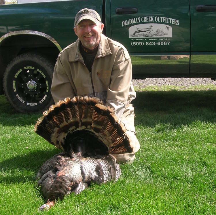 Man displaying his turkey at Deadman Creek Outfitters
